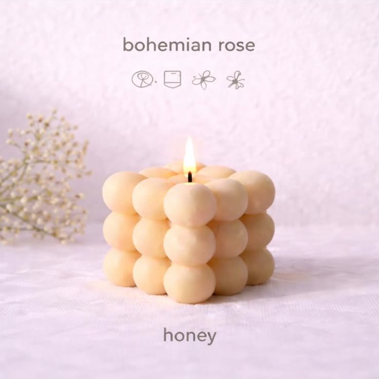 A lit Honey Bubble candle